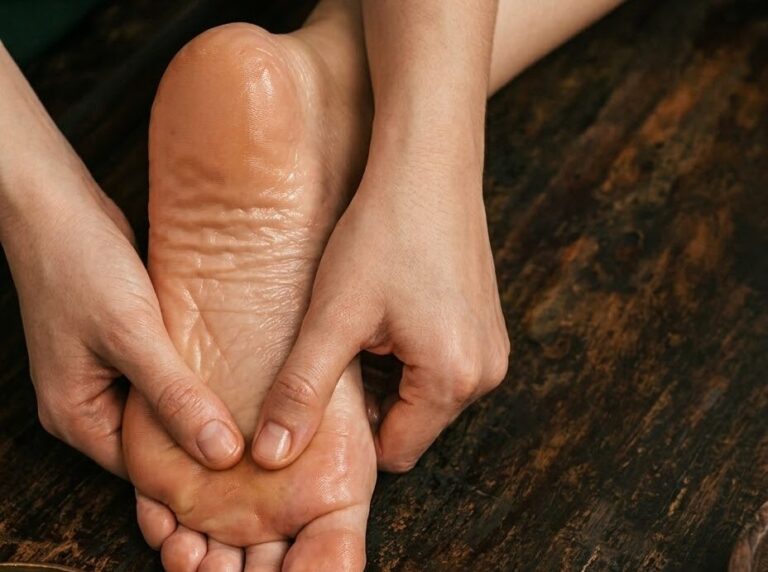 Therapist massaging the sole of the foot with warm oil
