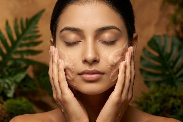 Woman applying a herbal face pack to her cheeks