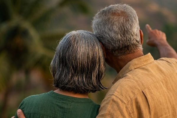 Older couple standing together, looking out over the countryside