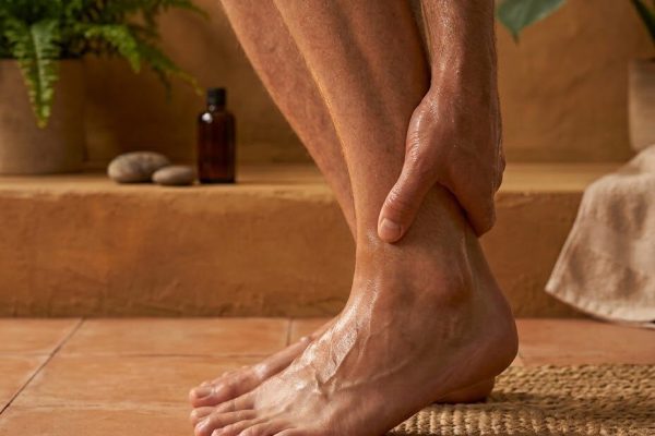 Hand holding the ankle and heel of a bare foot